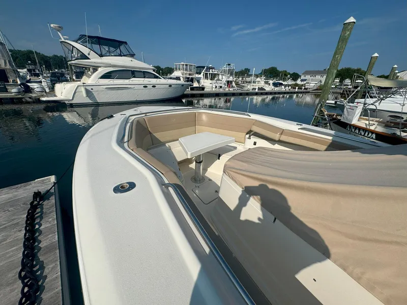 Slide: The Image of 2019 Sailfish 360 CC boat docked at marina with seating area and table. - 10