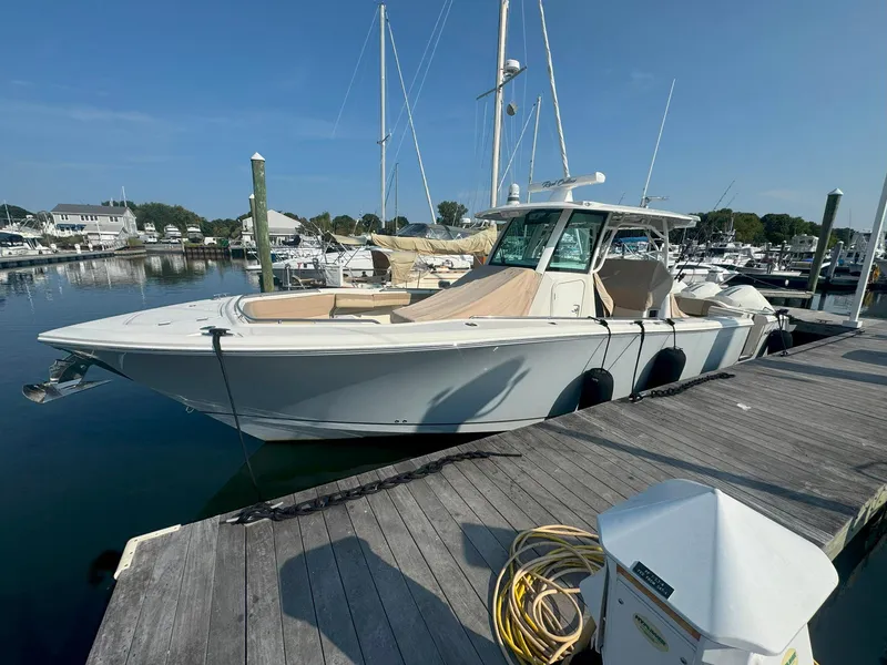 Slide: The Image of 2019 Sailfish 360 CC boat docked at a marina under clear blue skies. - 12