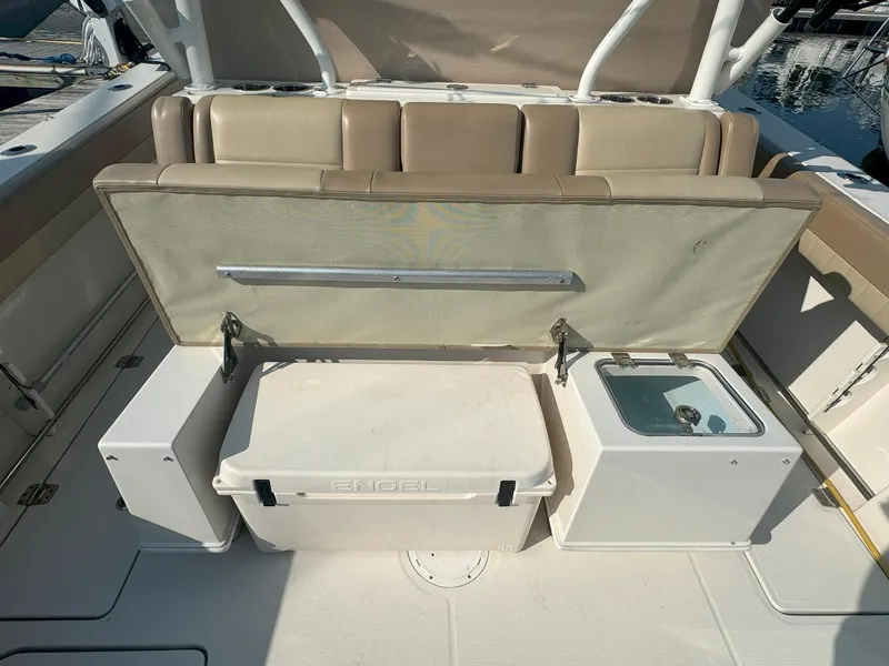 Slide: The Image of 2019 Sailfish 360 CC boat interior with seating, cooler, and storage compartments. - 19