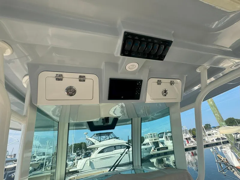 Slide: The Image of 2019 Sailfish 360 CC boat interior with storage compartments and marina view. - 21