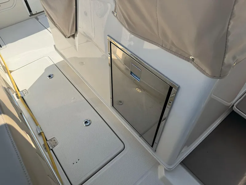 Slide: The Image of 2019 Sailfish 360 CC boat deck with storage compartment and beige cover. - 24