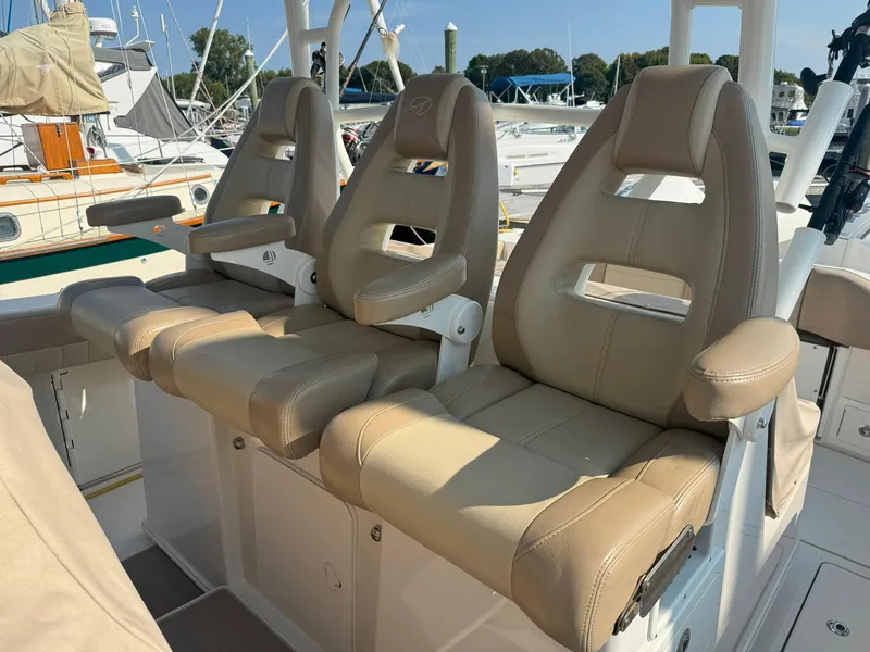 Slide: The Image of 2019 Sailfish 360 CC boat with beige cushioned seats at a marina. - 26