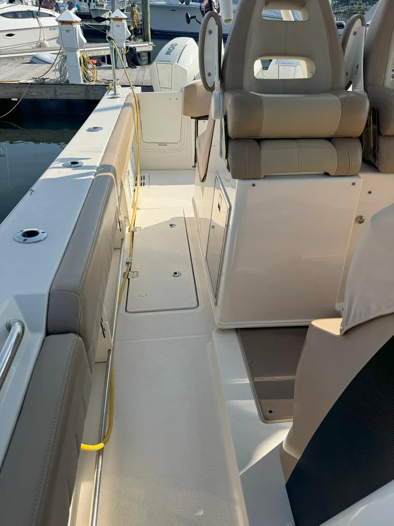 Slide: The Image of 2019 Sailfish 360 CC boat interior with seating and deck view at a marina. - 30