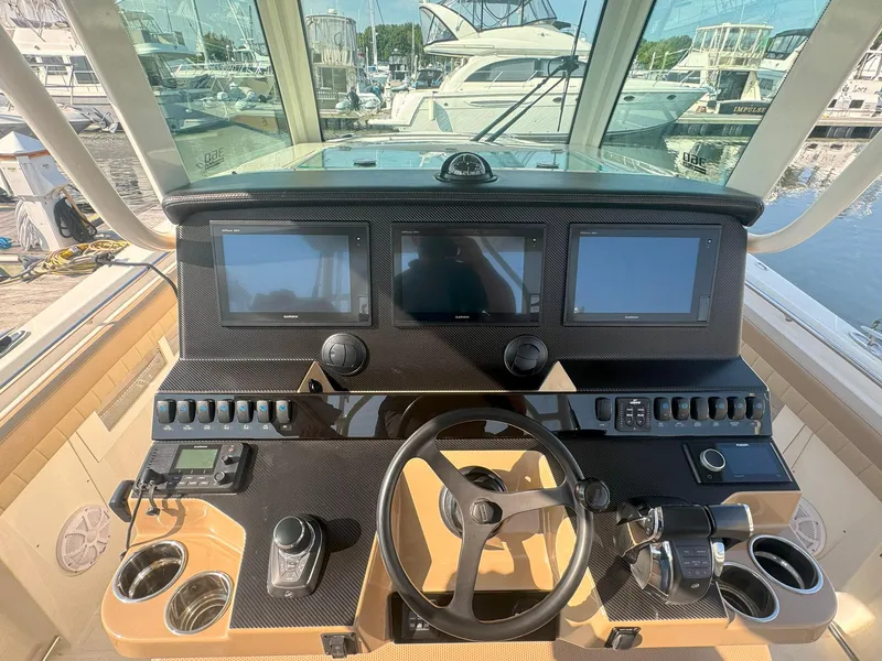 Slide: The Image of 2019 Sailfish 360 CC boat dashboard with navigation screens and controls at marina. - 34