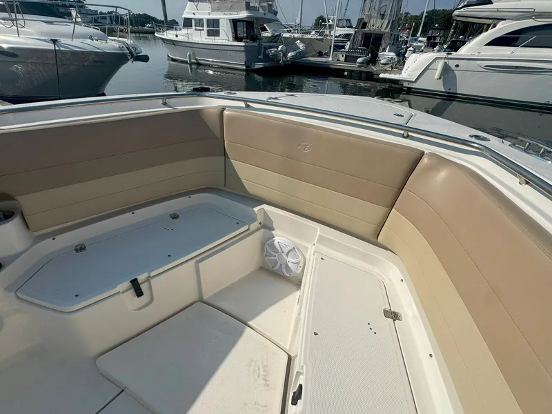 Slide: The Image of 2019 Sailfish 360 CC boat interior with beige seating, docked at marina. - 46