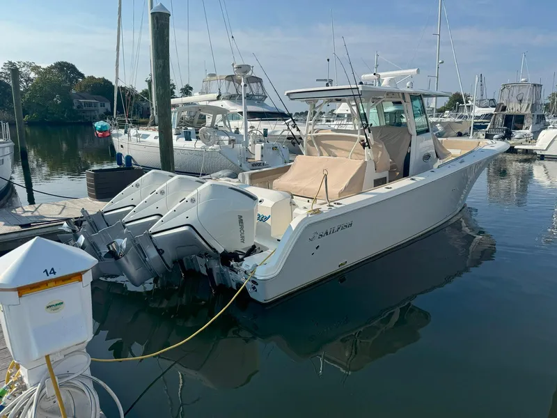 Slide: The Image of 2019 Sailfish 360 CC boat docked in a marina with twin outboard engines. - 5