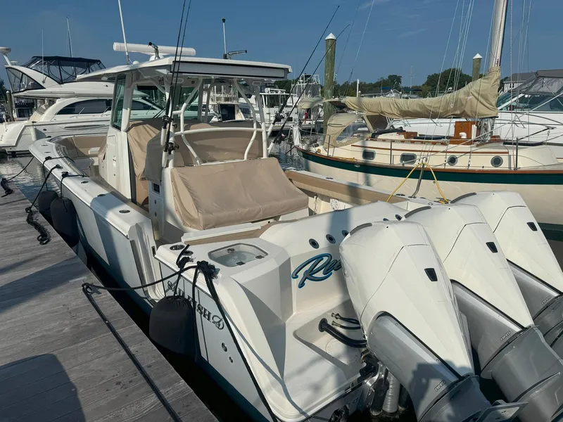 Slide: The Image of 2019 Sailfish 360 CC boat docked, featuring triple outboard engines. - 7