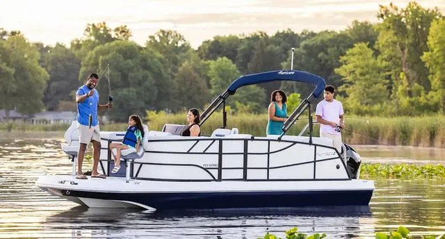 Slide: The Image of Family enjoying fishing on a 2025 Hurricane FD2260REF boat in a serene lake setting. - 1