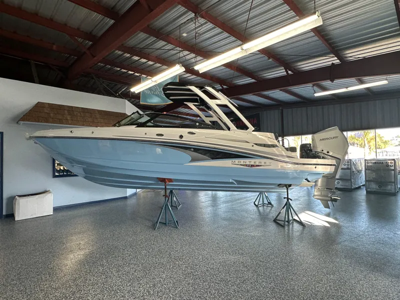 Slide: The Image of 2025 Monterey M45 boat displayed indoors on stands, showcasing sleek design and blue hull. - 10