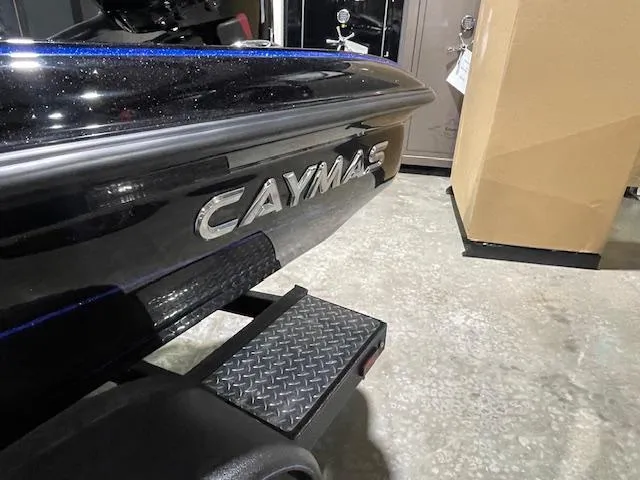 Slide: The Image of 2025 Caymas CX 20 boat, black exterior, displayed indoors on a trailer. - 13