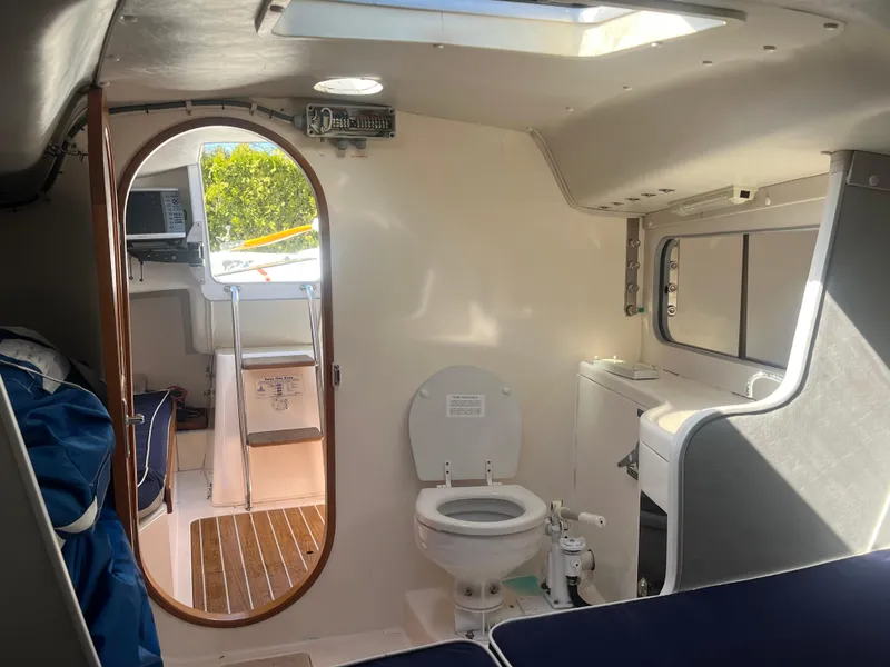 Slide: The Image of Interior of 2005 J Boats J/100 sailboat featuring compact cabin with toilet and seating. - 13