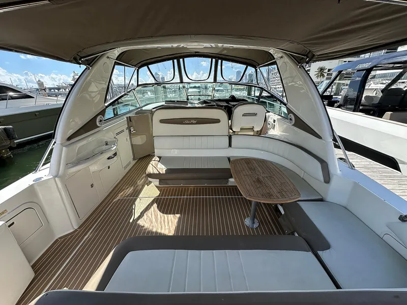 Slide: The Image of 1999 Sea Ray 400 Sundancer interior with seating and table, docked at marina. - 10