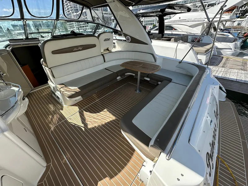 Slide: The Image of 1999 Sea Ray 400 Sundancer yacht interior with seating and table, docked at marina. - 11