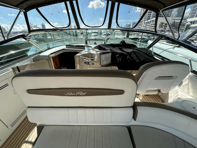 Slide: The Image of 1999 Sea Ray 400 Sundancer yacht interior with helm and seating, docked at marina. - 15