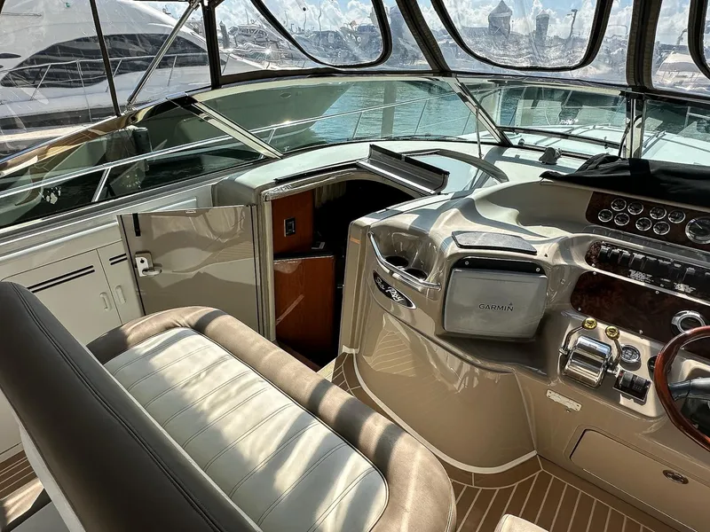 Slide: The Image of 1999 Sea Ray 400 Sundancer helm with Garmin navigation, luxurious seating, and modern controls. - 19