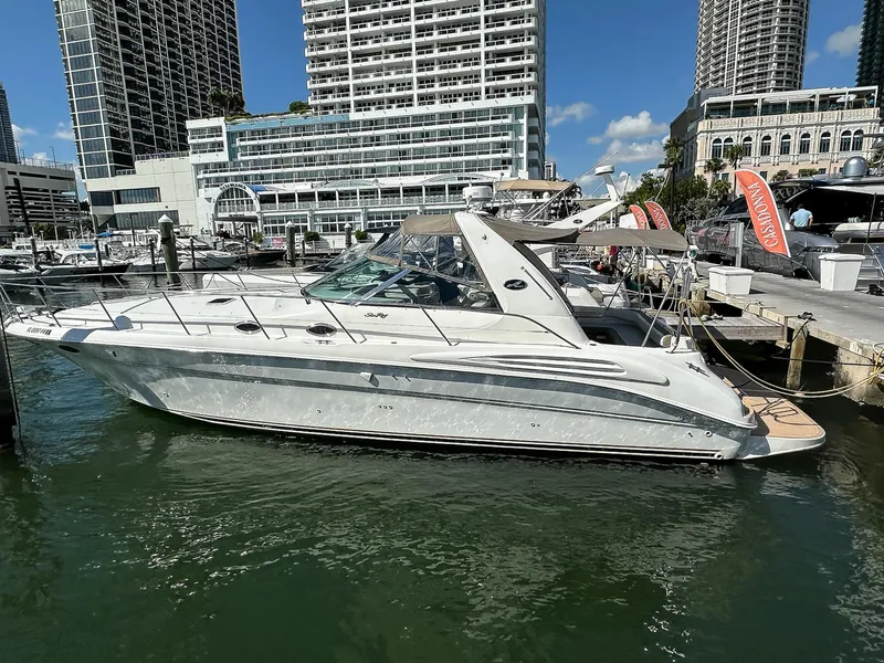 Slide: The Image of 1999 Sea Ray 400 Sundancer yacht docked in a marina with cityscape background. - 2
