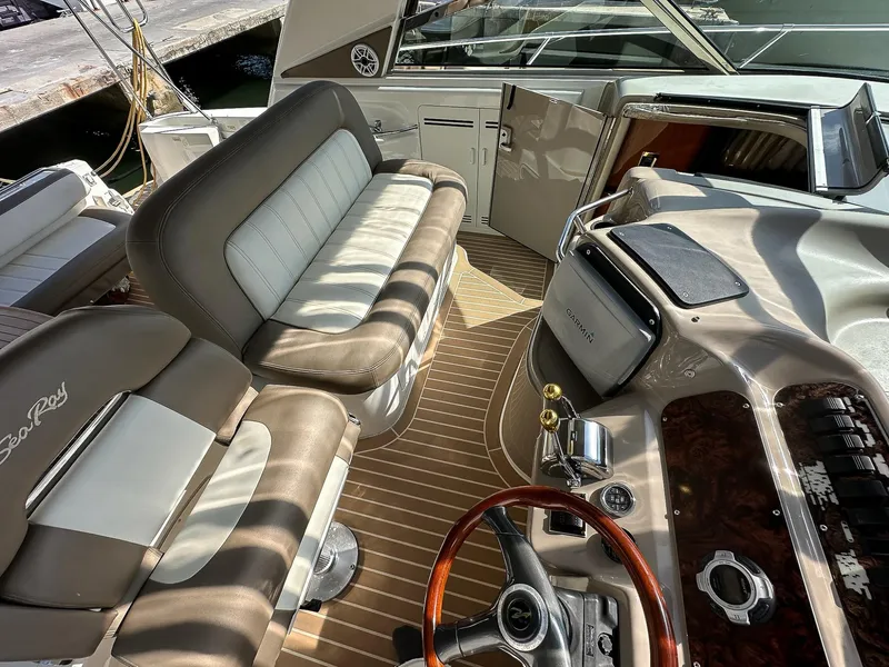 Slide: The Image of 1999 Sea Ray 400 Sundancer cockpit with plush seating and modern navigation equipment. - 20