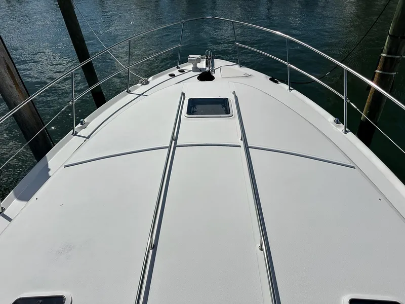 Slide: The Image of 1999 Sea Ray 400 Sundancer yacht deck with railing, docked on calm water. - 23