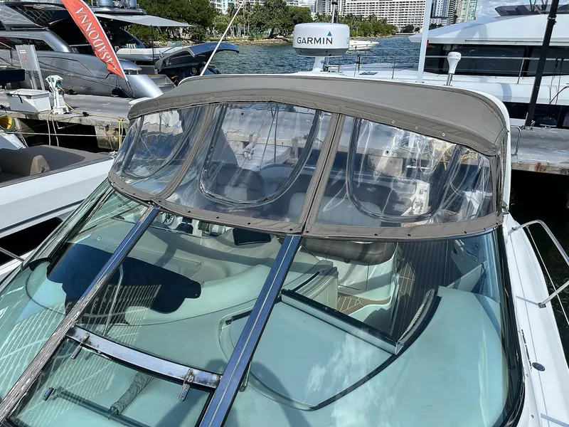 Slide: The Image of 1999 Sea Ray 400 Sundancer yacht docked, featuring a clear canopy and Garmin equipment. - 25