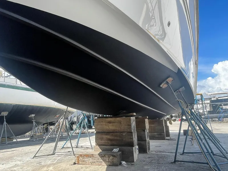 Slide: The Image of 1999 Sea Ray 400 Sundancer yacht on stands in a boatyard under clear blue sky. - 29