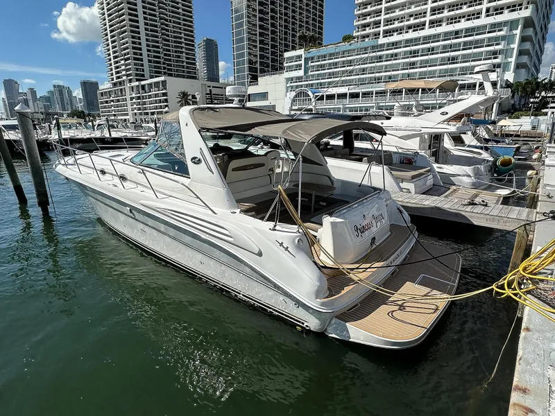 Slide: The Image of 1999 Sea Ray 400 Sundancer yacht docked in a marina with city skyline. - 3