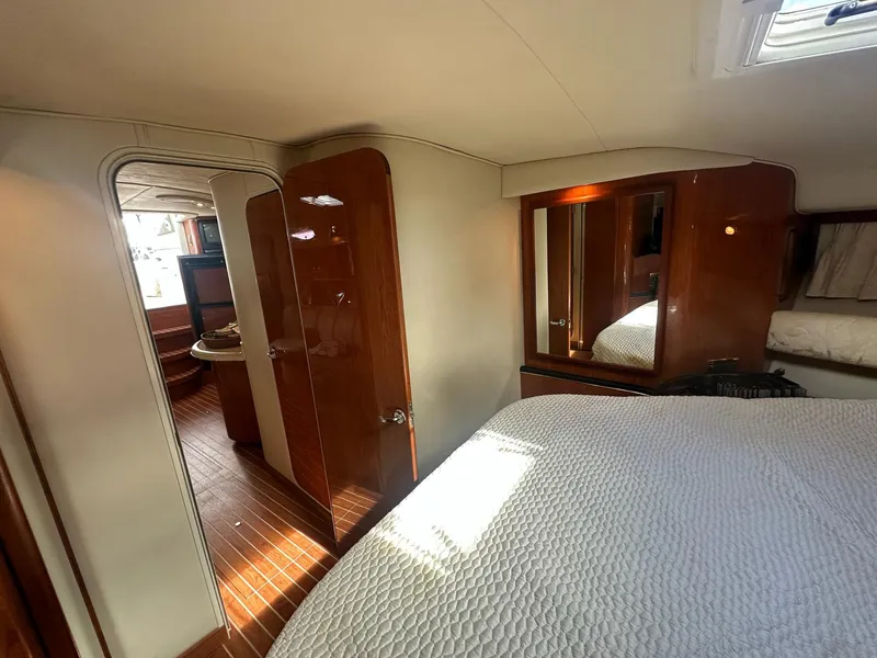 Slide: The Image of Interior of 1999 Sea Ray 400 Sundancer yacht, featuring cozy bedroom and wooden finishes. - 42