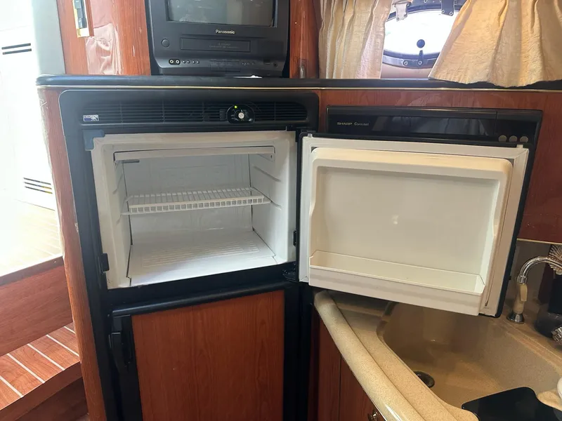 Slide: The Image of 1999 Sea Ray 400 Sundancer kitchen with open fridge and microwave. - 50