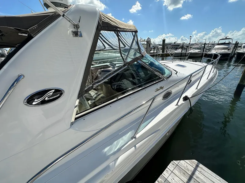 Slide: The Image of 1999 Sea Ray 400 Sundancer yacht docked under a clear blue sky. - 6