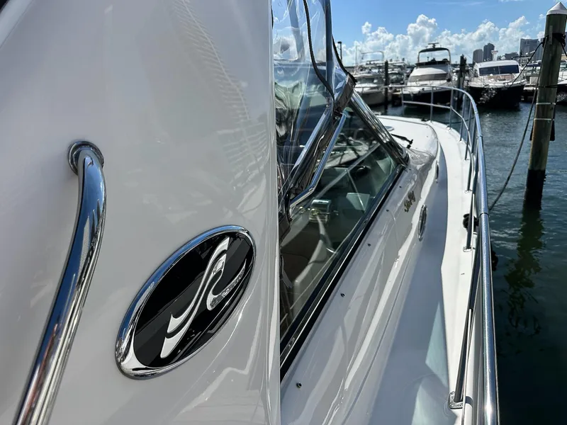 Slide: The Image of 1999 Sea Ray 400 Sundancer yacht docked at marina, showcasing sleek design and chrome details. - 7