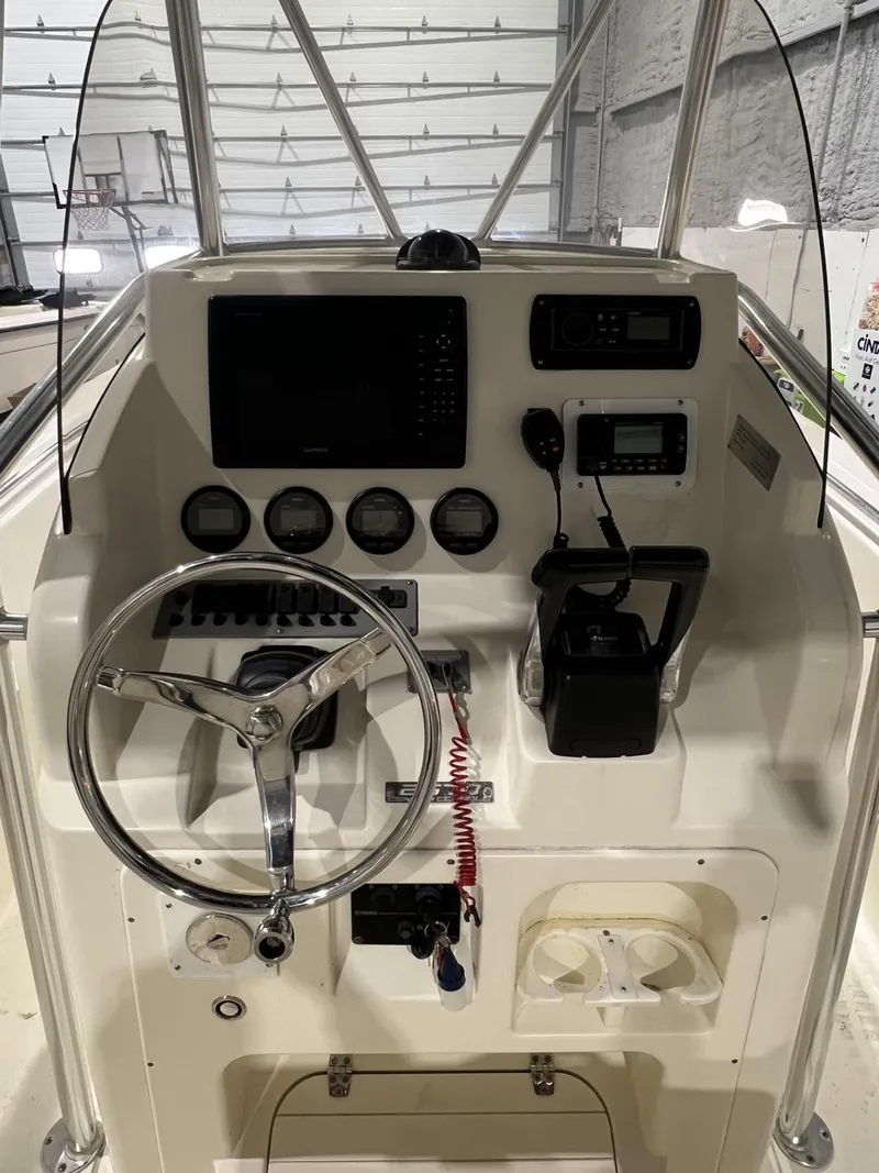 Slide: The Image of 2005 Pursuit 2570 Center Console boat dashboard with steering wheel and navigation controls. - 14