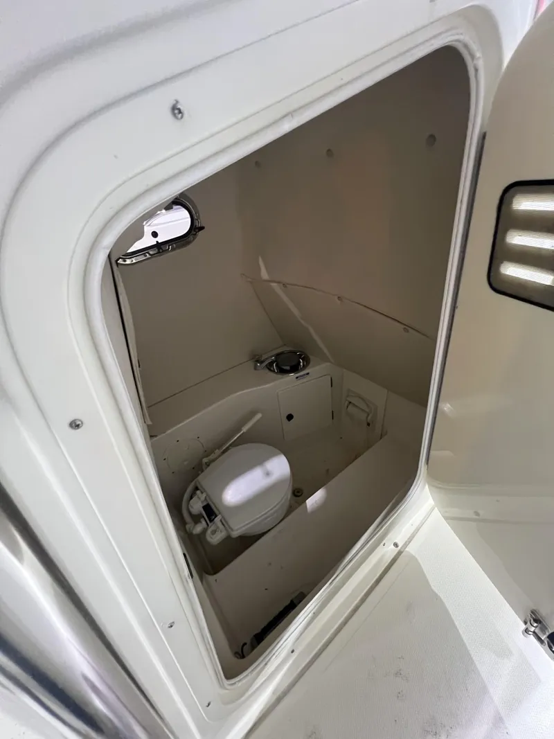 Slide: The Image of 2005 Pursuit 2570 Center Console boat interior with compact marine toilet. - 18