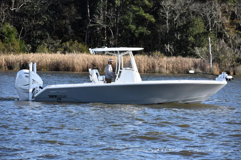Slide: The Image of 2024 Pathfinder 2700 Open boat on a calm lake with forested background. - 2