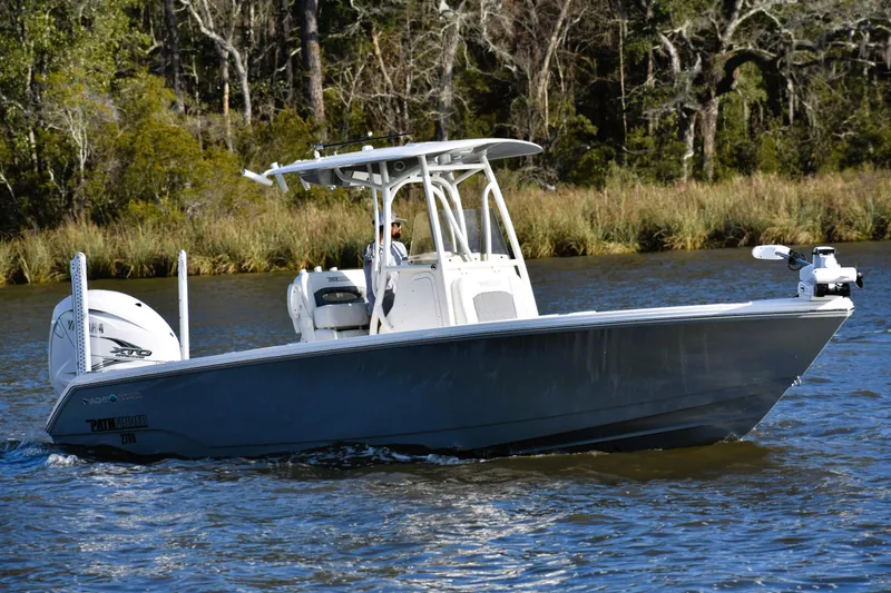 Slide: The Image of 2024 Pathfinder 2700 Open boat cruising on a river with forested background. - 3