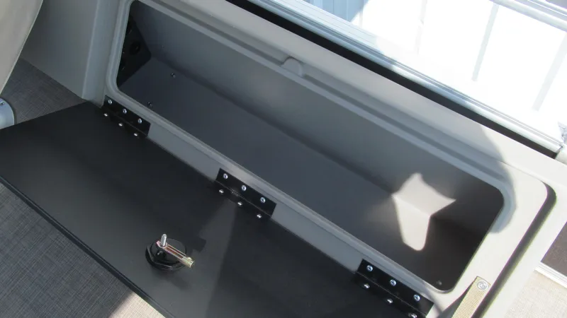 Slide: The Image of Storage compartment of 2023 Sun Tracker SportFish 22 DLX boat, open with key inside. - 11