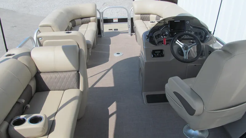 Slide: The Image of 2023 Sun Tracker SportFish 22 DLX pontoon boat interior with beige seating and steering console. - 14
