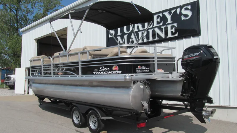 Slide: The Image of 2023 Sun Tracker SportFish 22 DLX pontoon boat on trailer at Storey's Marine. - 2