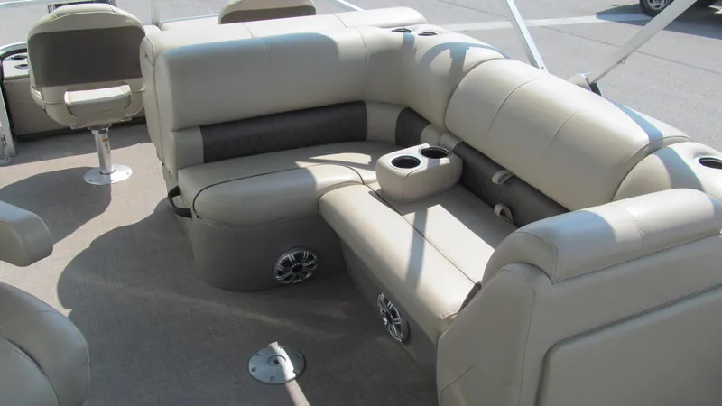 Slide: The Image of 2023 Sun Tracker SportFish 22 DLX pontoon boat interior with beige seating and cup holders. - 5