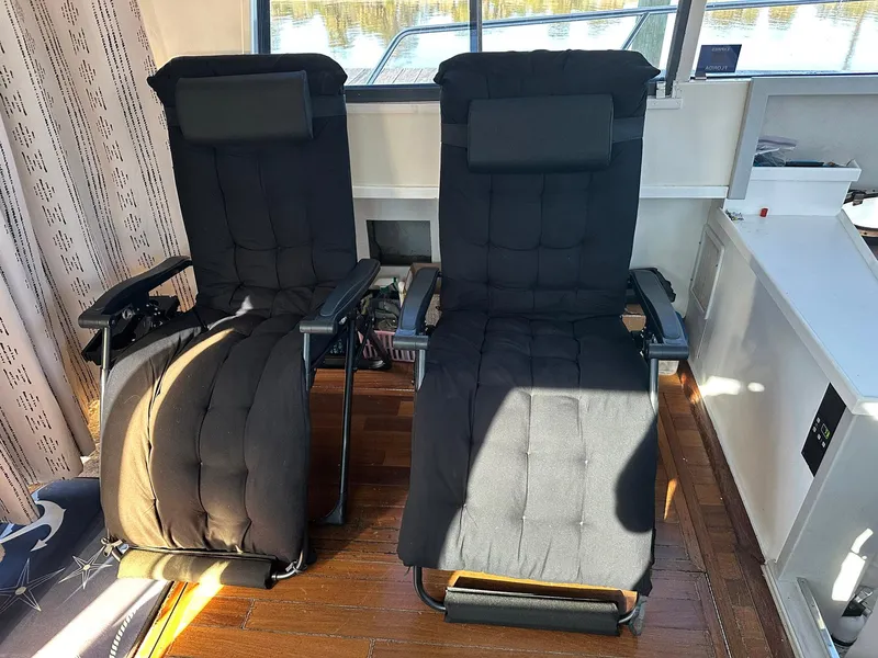Slide: The Image of Two black recliner chairs inside a 1989 Tiara Yachts 3100 Convertible. - 2