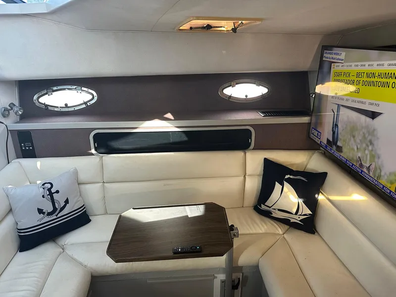 Slide: The Image of Interior of 1989 Tiara Yachts 3100 Convertible with cozy seating and nautical decor. - 3