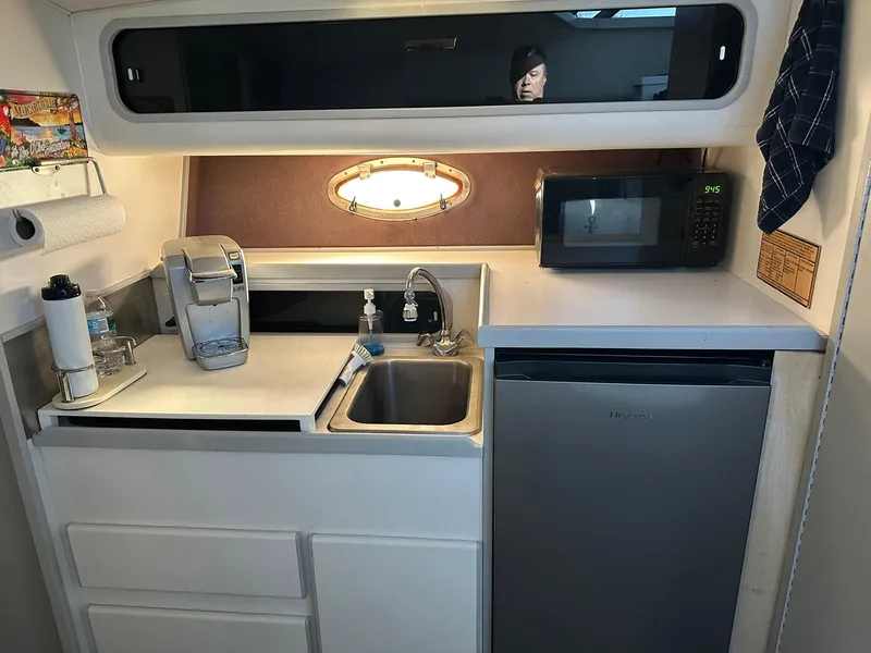 Slide: The Image of 1989 Tiara Yachts 3100 Convertible kitchen with sink, microwave, and compact fridge. - 4