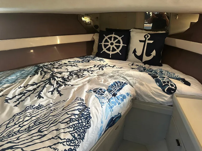 Slide: The Image of Cozy cabin interior of 1989 Tiara Yachts 3100 Convertible with nautical-themed bedding. - 5