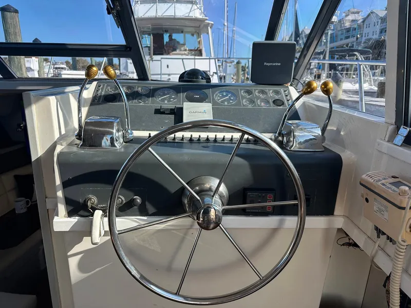 Slide: The Image of 1989 Tiara Yachts 3100 Convertible helm with steering wheel and control panel. - 7