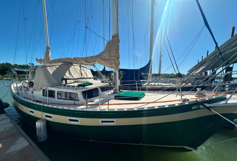 The Image of 1981 Islander Freeport Ketch sailboat docked under clear blue sky. - 0