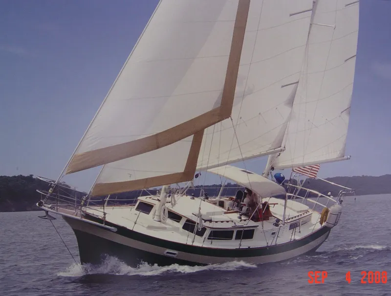 Slide: The Image of 1981 Islander Freeport Ketch sailing on open water with full sails. - 1