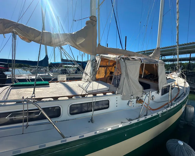 Slide: The Image of 1981 Islander Freeport Ketch sailboat docked under bright sunlight. - 11