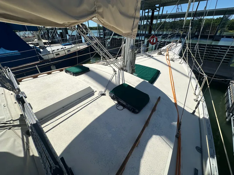 Slide: The Image of 1981 Islander Freeport Ketch sailboat deck with green cushions and rigging in marina. - 15