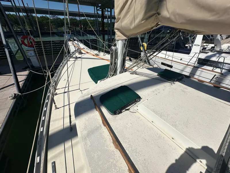 Slide: The Image of 1981 Islander Freeport Ketch sailboat deck with rigging and covered hatches in marina. - 16