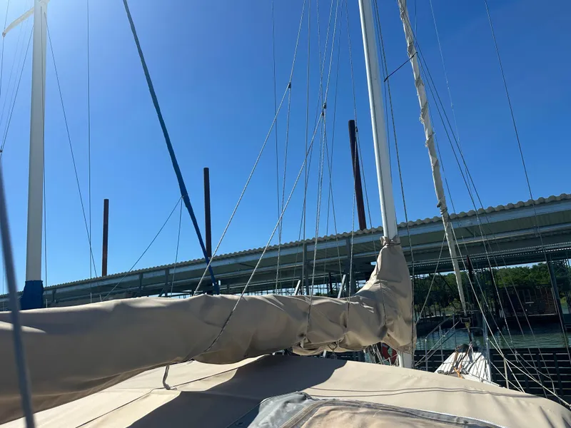 Slide: The Image of 1981 Islander Freeport Ketch sailboat with covered boom, docked under clear blue sky. - 22