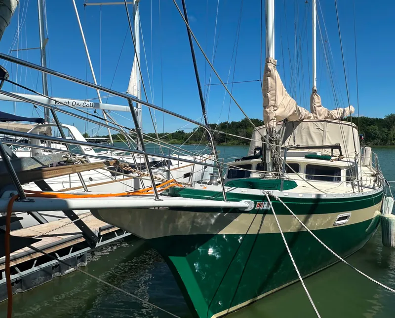 Slide: The Image of 1981 Islander Freeport Ketch sailboat docked in a marina under clear blue skies. - 27