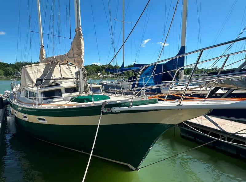 Slide: The Image of 1981 Islander Freeport Ketch sailboat docked in a marina under clear blue skies. - 29